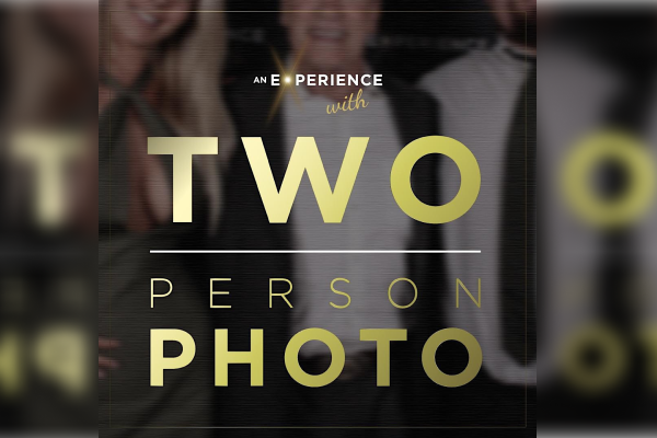 A blurred image background with large beige text overlay reading "An Experience with TWO PERSON PHOTO" across the center.